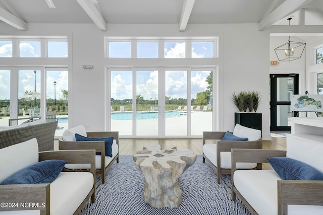 living room featuring beam ceiling, a towering ceiling, and wood-type flooring