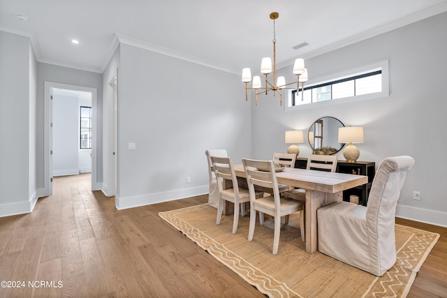 dining area featuring a chandelier, crown molding, and light hardwood / wood-style floors