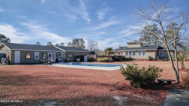 rear view of property with french doors, a patio area, and a fenced in pool