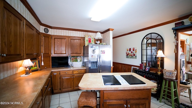 kitchen featuring light tile floors, crown molding, and stainless steel fridge