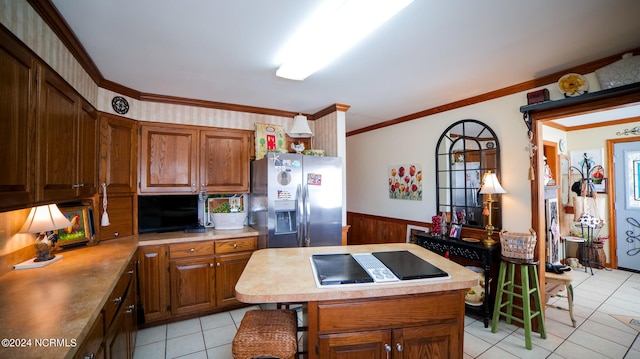 kitchen with stainless steel fridge with ice dispenser, a breakfast bar, ornamental molding, and light tile floors