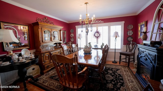 dining room with hardwood / wood-style floors, a chandelier, and crown molding