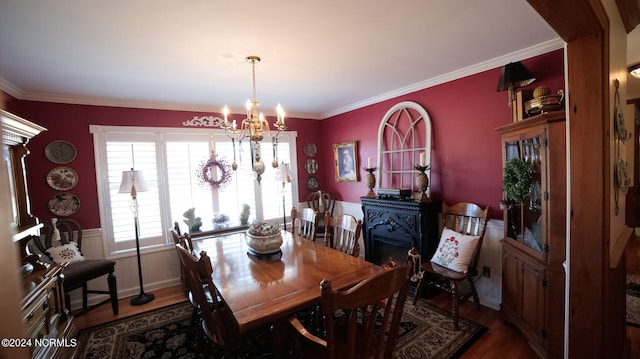 dining space featuring a chandelier, crown molding, and dark wood-type flooring