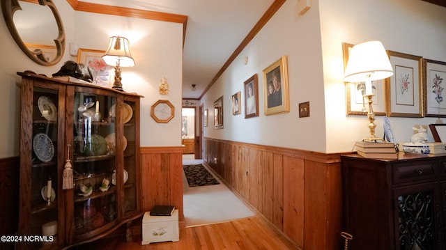 hall with ornamental molding and light hardwood / wood-style flooring