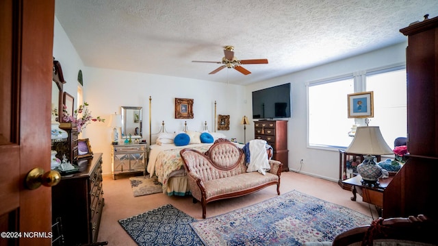 carpeted bedroom with ceiling fan and a textured ceiling