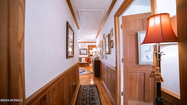 hallway with crown molding and light hardwood / wood-style floors