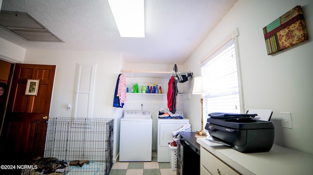 washroom featuring light tile floors, a textured ceiling, and independent washer and dryer