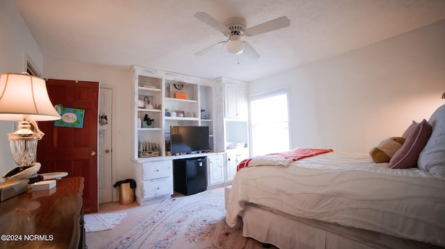 carpeted bedroom with fridge and ceiling fan