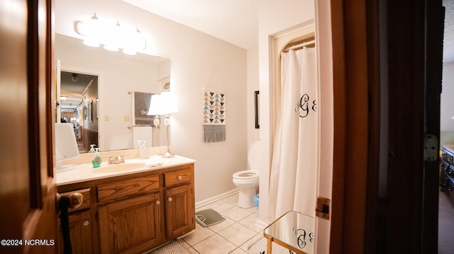 bathroom with tile floors, toilet, and oversized vanity