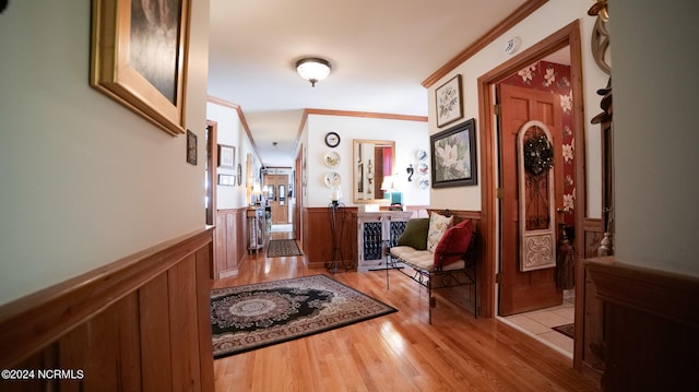 corridor with ornamental molding and light wood-type flooring