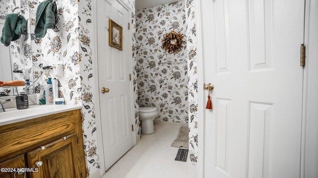 bathroom featuring toilet, tile flooring, and vanity