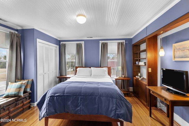 bedroom featuring a closet, ornamental molding, and light hardwood / wood-style floors