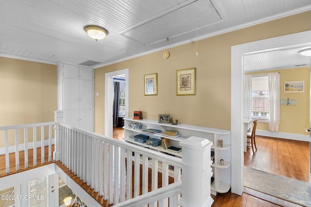 hallway with crown molding and light wood-type flooring