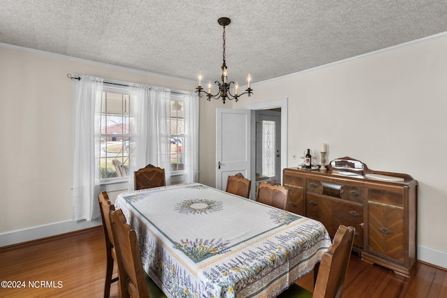 dining space featuring an inviting chandelier, ornamental molding, dark wood-type flooring, and a textured ceiling