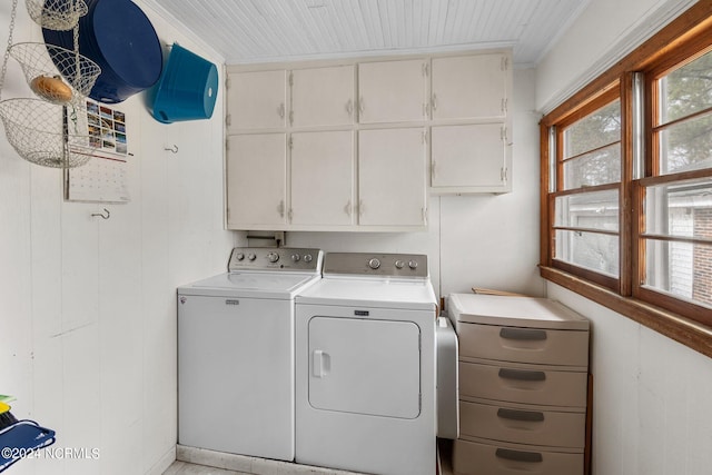 clothes washing area featuring crown molding, cabinets, separate washer and dryer, and a wealth of natural light