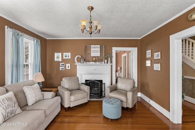 living room featuring a notable chandelier, a brick fireplace, a textured ceiling, crown molding, and dark hardwood / wood-style floors