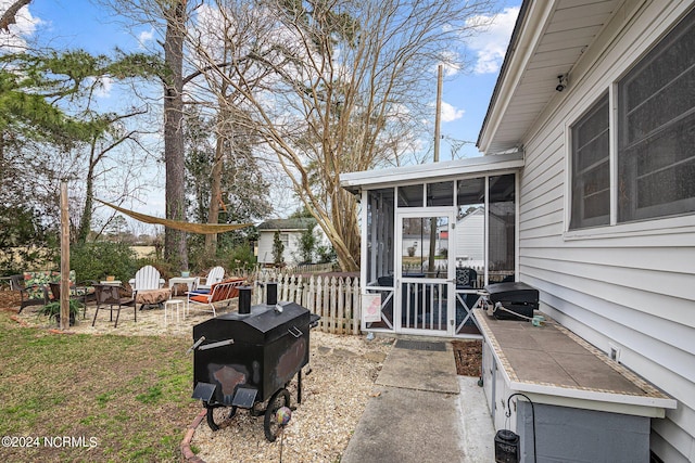 view of patio featuring a fire pit and a sunroom