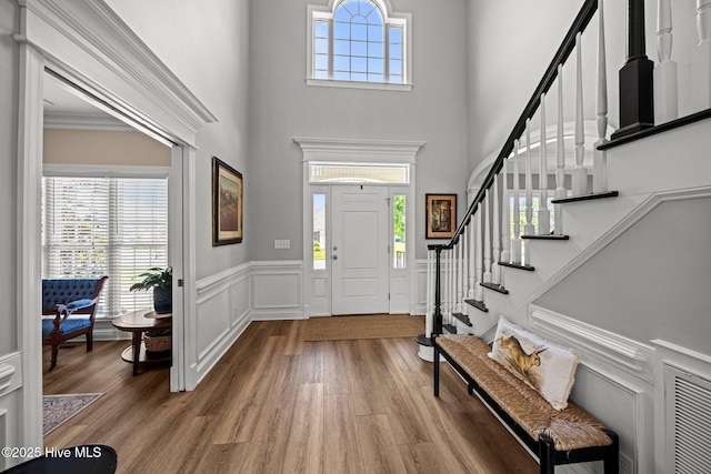4441 Lagan Cir, Winterville, NC 28590 - foyer featuring stairway, wood finished floors, a towering ceiling, a wainscoted wall, and a decorative wall