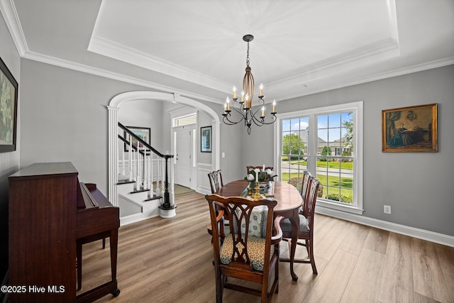 4441 Lagan Cir, Winterville, NC 28590 - dining space featuring arched walkways, light wood-style flooring, a chandelier, a raised ceiling, and crown molding