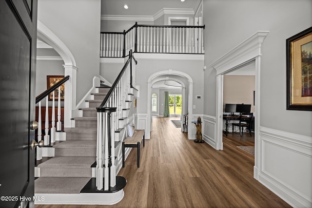 4441 Lagan Cir, Winterville, NC 28590 - foyer featuring arched walkways, ornate columns, ornamental molding, stairway, and a wainscoted wall