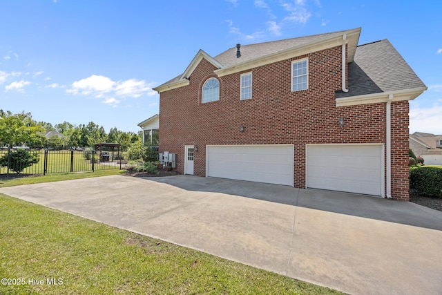 4441 Lagan Cir, Winterville, NC 28590 - view of property exterior with a garage, driveway, brick siding, and roof with shingles