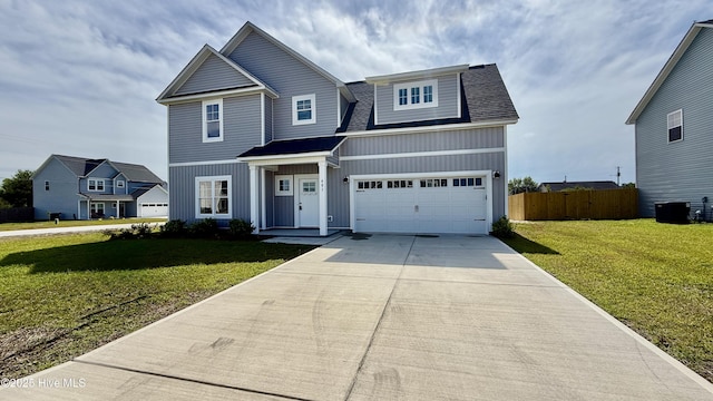 401 Bay Harbor Ct, Hubert, NC 28539 - view of front of home with fence, concrete driveway, board and batten siding, a shingled roof, and a front lawn