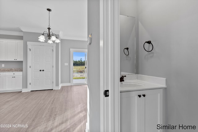 bathroom featuring vanity, crown molding, a notable chandelier, and hardwood / wood-style floors