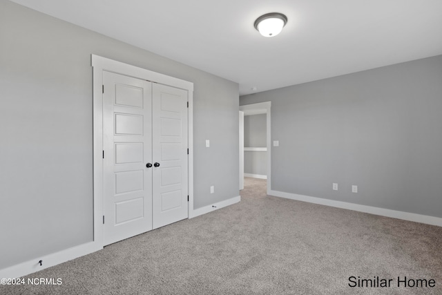 unfurnished bedroom featuring a closet and carpet flooring