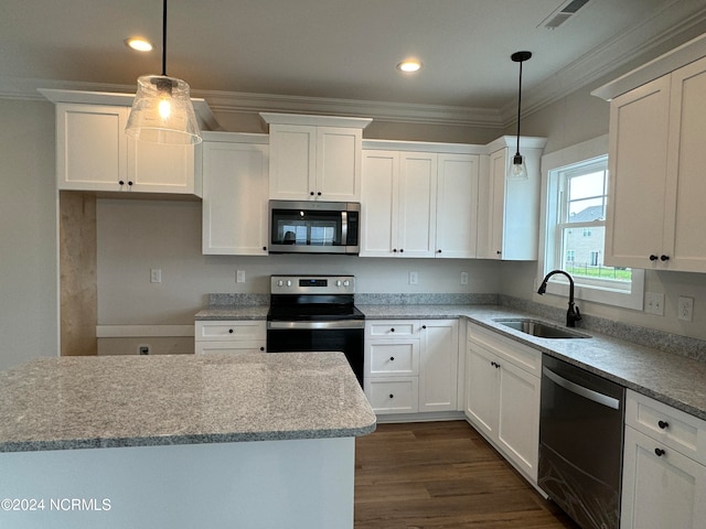 kitchen with ornamental molding, appliances with stainless steel finishes, pendant lighting, and sink