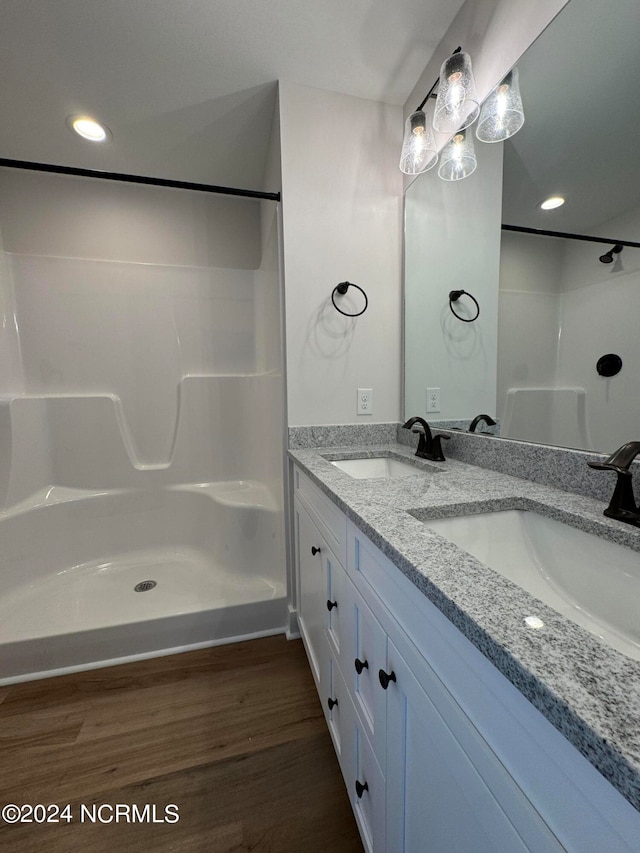 bathroom with double vanity and hardwood / wood-style floors