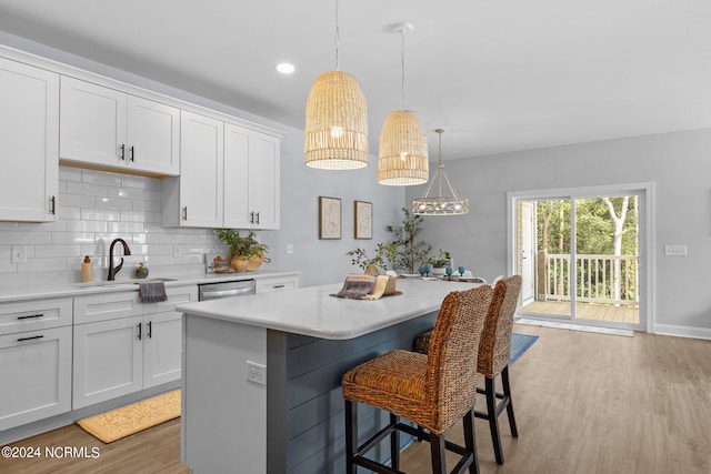 kitchen featuring white cabinets, a center island, and sink