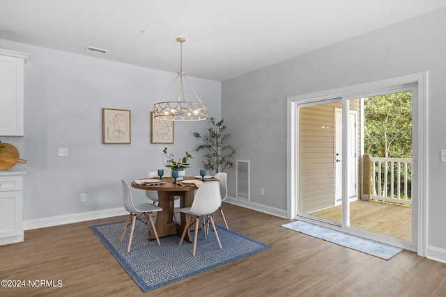 dining area featuring dark wood-type flooring and a notable chandelier