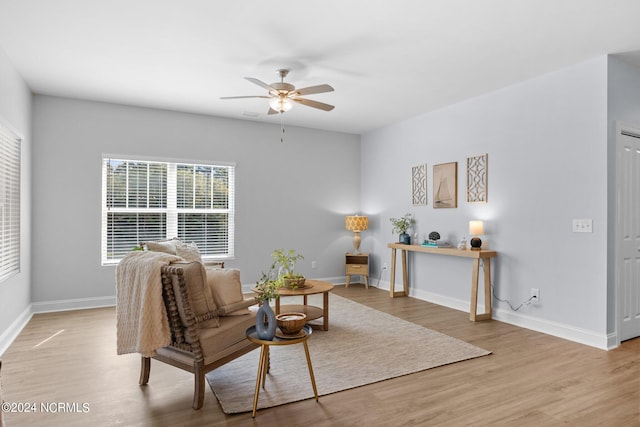 living area with ceiling fan and light hardwood / wood-style floors