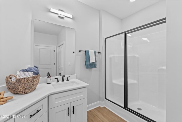 bathroom featuring vanity, wood-type flooring, and a shower with door