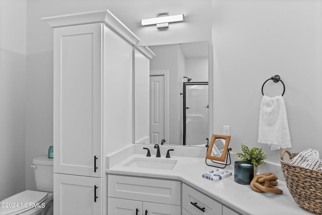 bathroom with vanity, toilet, and a shower with shower door