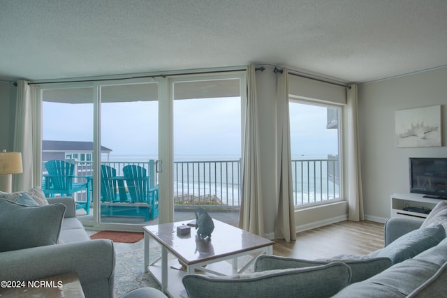 2000 New River Inlet Rd Unit 3309, North Topsail Beach, NC 28460 - living room featuring a textured ceiling, light hardwood / wood-style flooring, and a water view