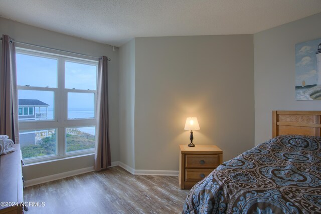 2000 New River Inlet Rd Unit 3309, North Topsail Beach, NC 28460 - bedroom with a textured ceiling and light wood-type flooring