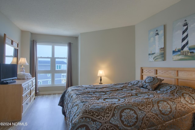 2000 New River Inlet Rd Unit 3309, North Topsail Beach, NC 28460 - bedroom with a textured ceiling and light wood-type flooring