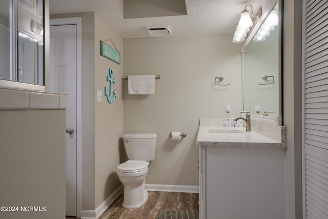 2000 New River Inlet Rd Unit 3309, North Topsail Beach, NC 28460 - bathroom with toilet, large vanity, hardwood / wood-style floors, and a textured ceiling