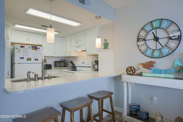 2000 New River Inlet Rd Unit 3309, North Topsail Beach, NC 28460 - kitchen featuring white refrigerator, stove, tasteful backsplash, white cabinets, and hanging light fixtures
