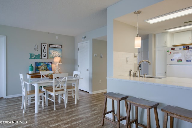 2000 New River Inlet Rd Unit 3309, North Topsail Beach, NC 28460 - kitchen featuring hanging light fixtures, sink, white refrigerator, white cabinetry, and dark hardwood / wood-style floors