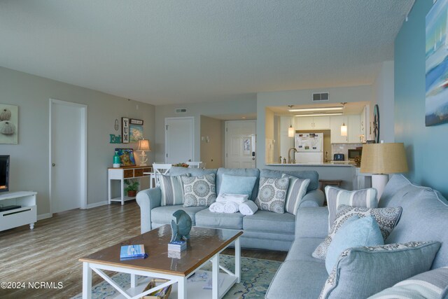 2000 New River Inlet Rd Unit 3309, North Topsail Beach, NC 28460 - living room featuring sink, hardwood / wood-style flooring, and a textured ceiling