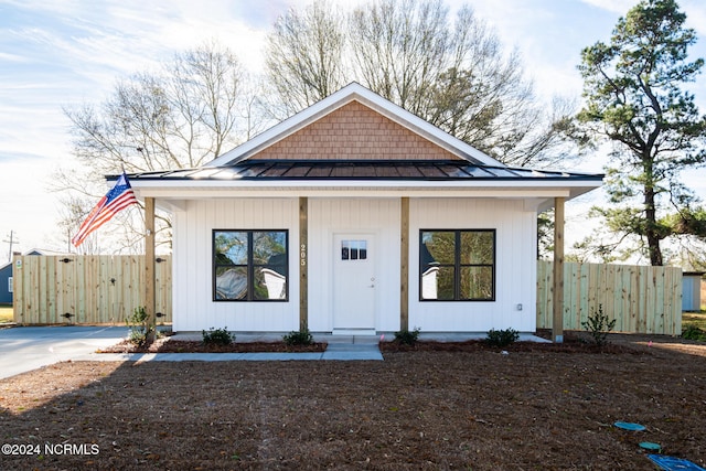 607 N Timberly Ln, Burgaw, NC 28425 - view of front facade featuring a standing seam roof, fence, covered porch, and metal roof