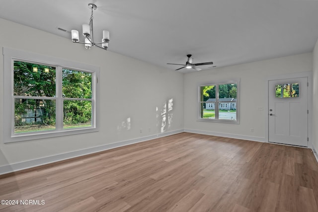 interior space featuring ceiling fan with notable chandelier and light hardwood / wood-style floors