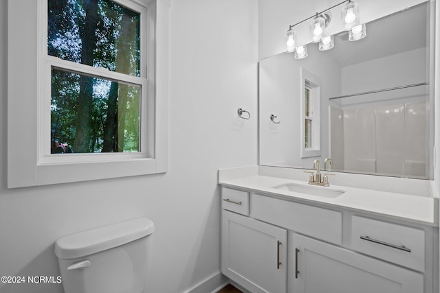 bathroom featuring vanity, toilet, and walk in shower