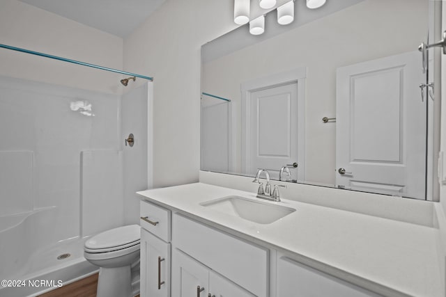 bathroom featuring vanity, toilet, a shower, and hardwood / wood-style floors