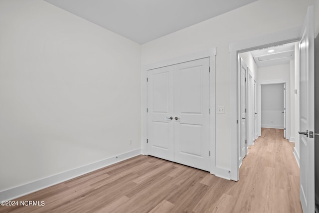 unfurnished bedroom with a closet and light wood-type flooring