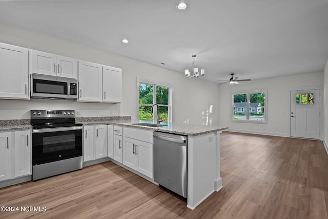 607 N Timberly Ln, Burgaw, NC 28425 - kitchen featuring stainless steel appliances, a sink, a peninsula, white cabinetry, and healthy amount of natural light