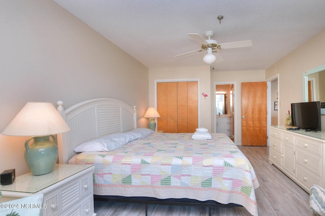 bedroom with ensuite bathroom, a closet, ceiling fan, and light wood-type flooring