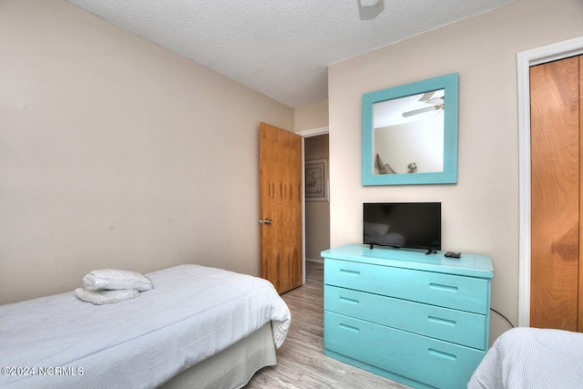 bedroom with light hardwood / wood-style floors and a textured ceiling